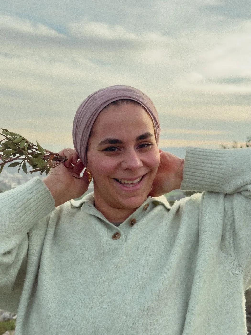 Sabreen Haj Ahmad outdoors holding a sprig of wild herbs